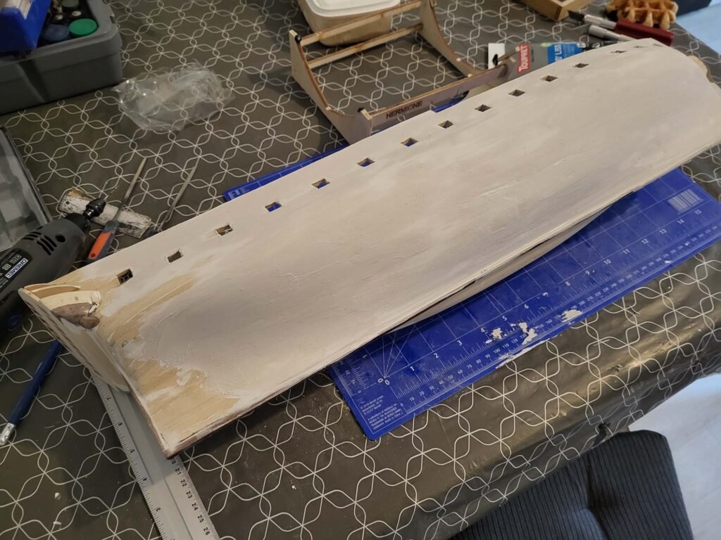 Planche bois avec trous alignés et règle de découpe bleue
