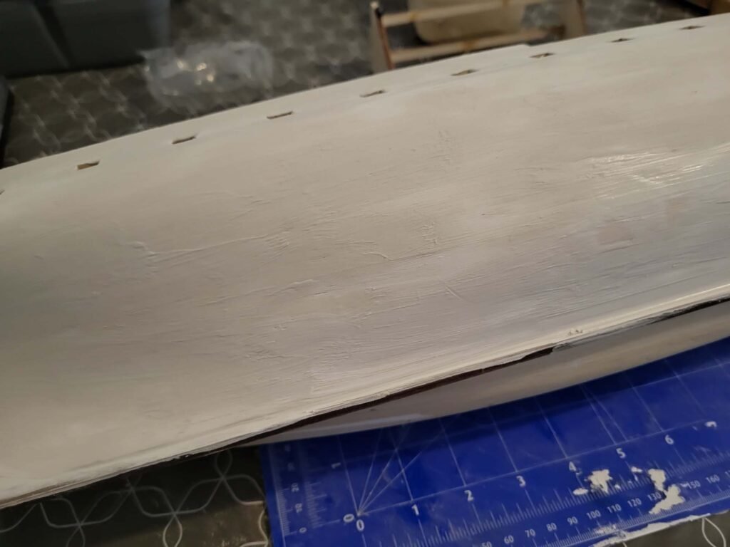 Planche blanche percée avec règle de découpe bleue