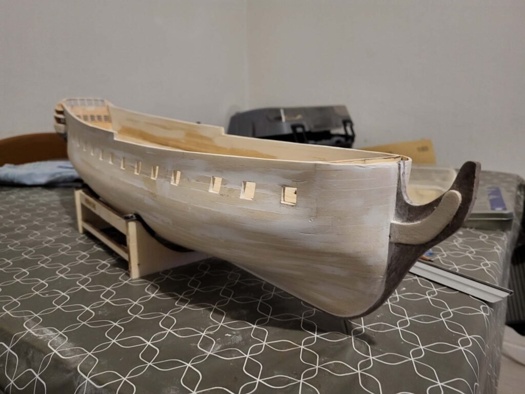Maquette navire bois blanc avec hublots et supports bruns