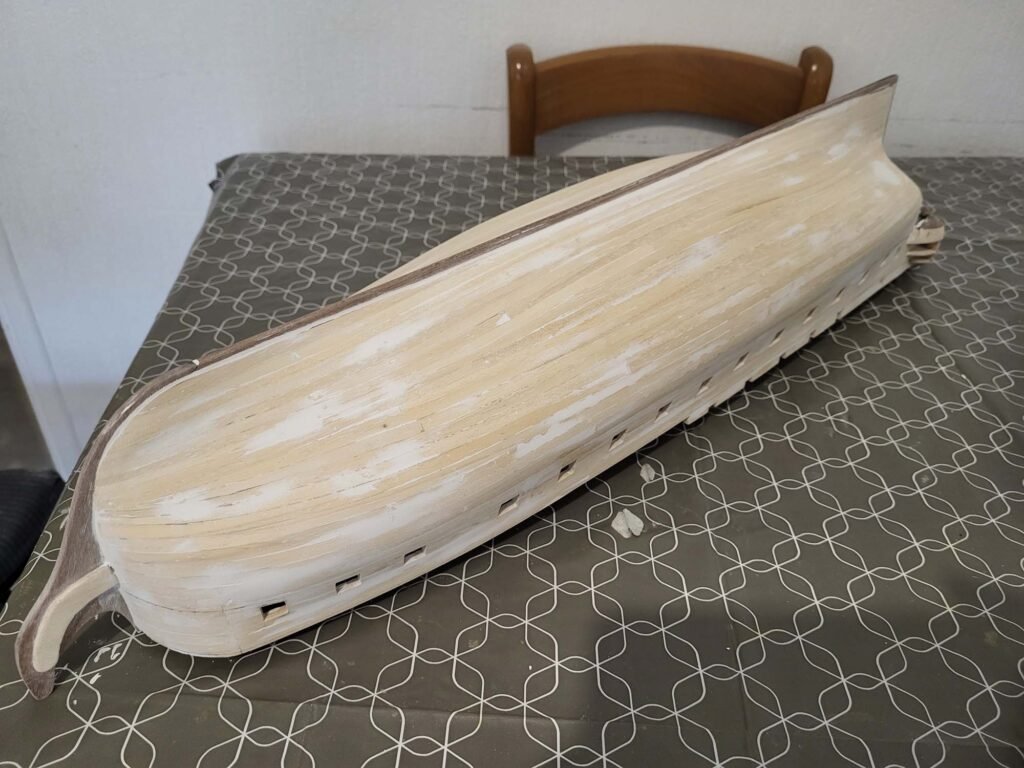 Cercueil en bois clair allongé sur lit avec matelas