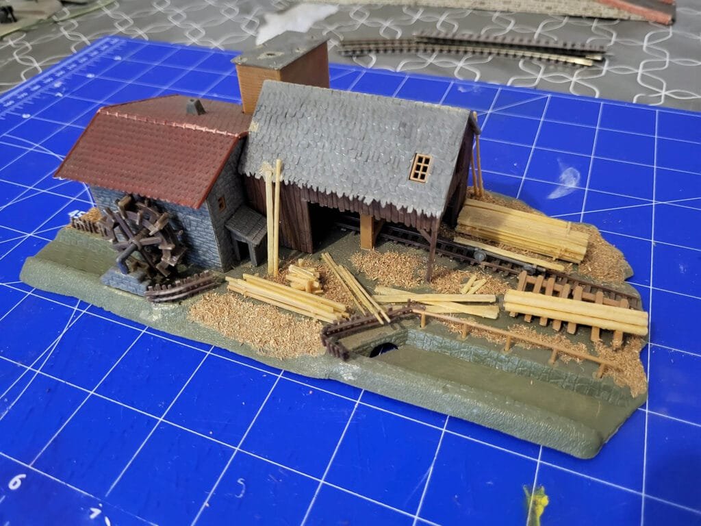 Maquette scierie miniature avec bâtiments et bois
