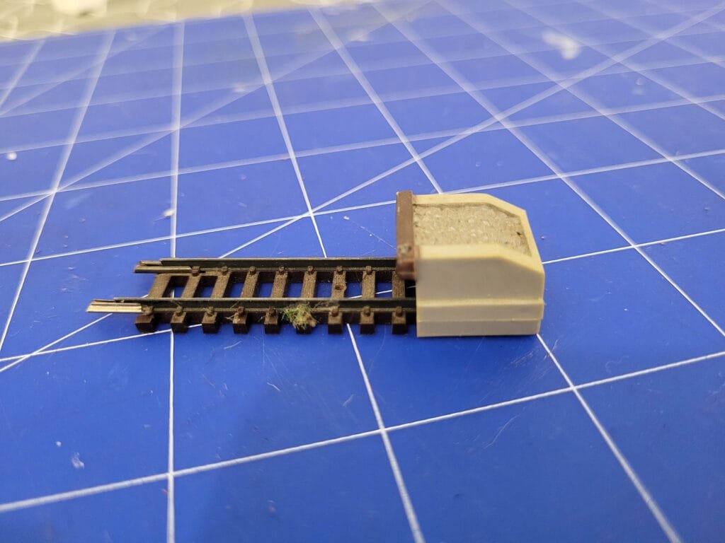 Connecteur rail miniature sur un tapis de découpe bleu