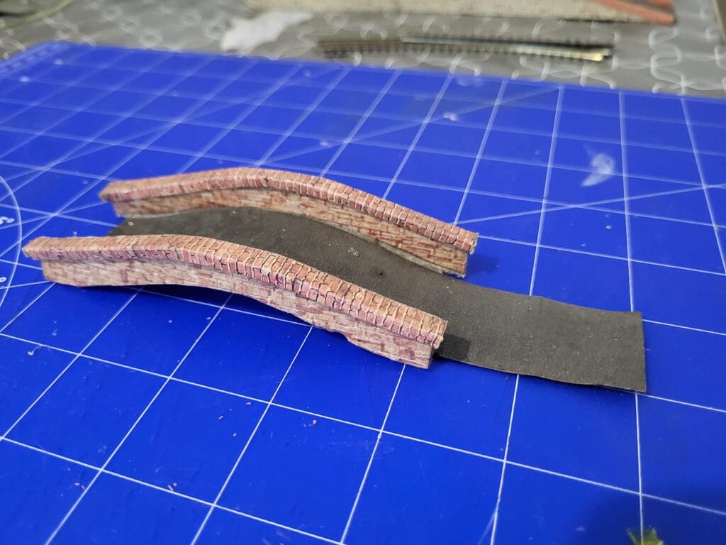Petit pont en carton sur planche de coupe bleue