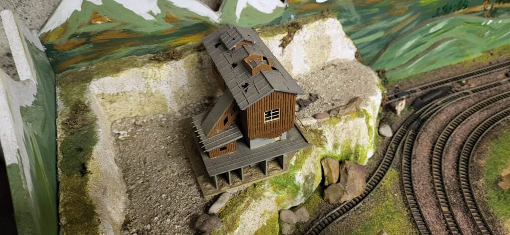 Usine miniature sur maquette ferroviaire avec voies