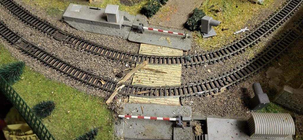 Maquette ferroviaire miniature avec voies et passage à niveau