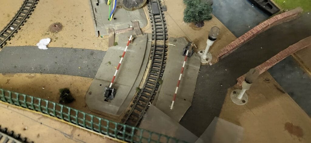 Maquette ferroviaire miniature avec voies et passage à niveau