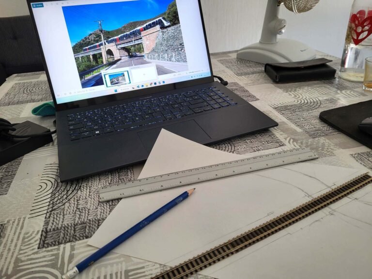 Laptop affichant train sur viaduc, bureau de travail
