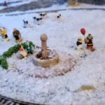 Scène miniature hivernale avec figurines personnages et fontaine