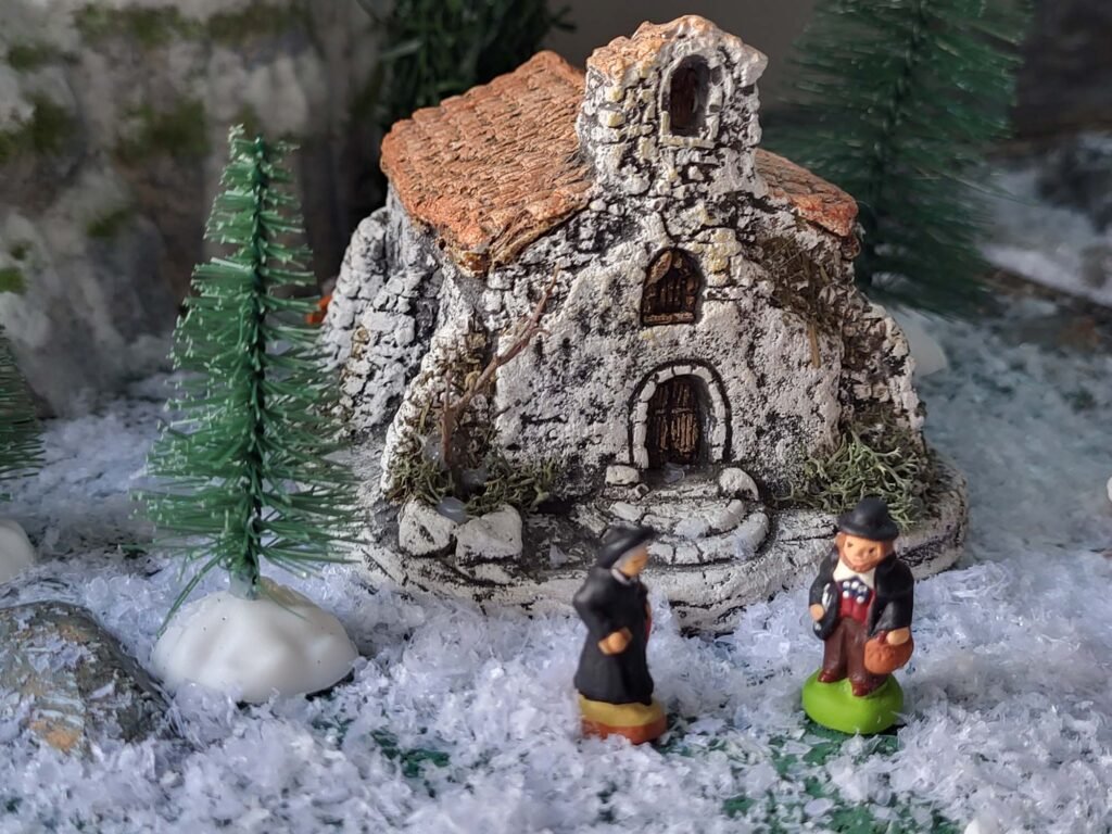 Maquette de village hivernal avec chapelle enneigée et figurines